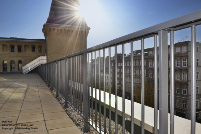 Panorama P-ST freestanding balustrade installed on a modern flat rooftop building, providing edge protection while maintaining the clean architectural design.