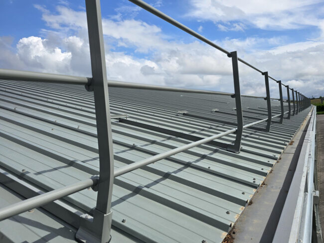 Curved Aluminium Edge Protection Following Roof Pitch at Longley Farm Close-up of curved post profile on Barrial® roof edge protection at Longley Farm, Holme Architecture